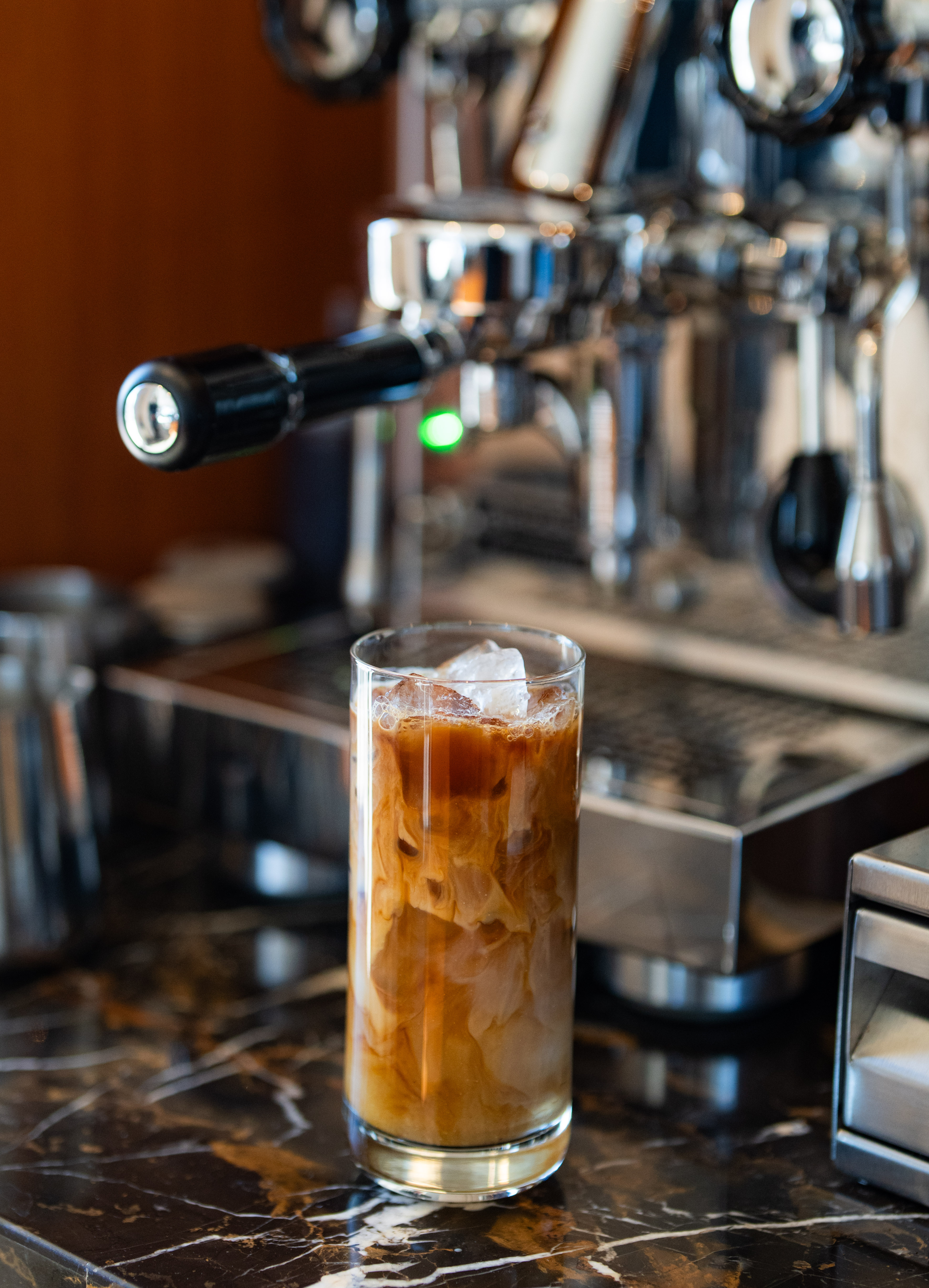 Iced latte in front of espresso machine