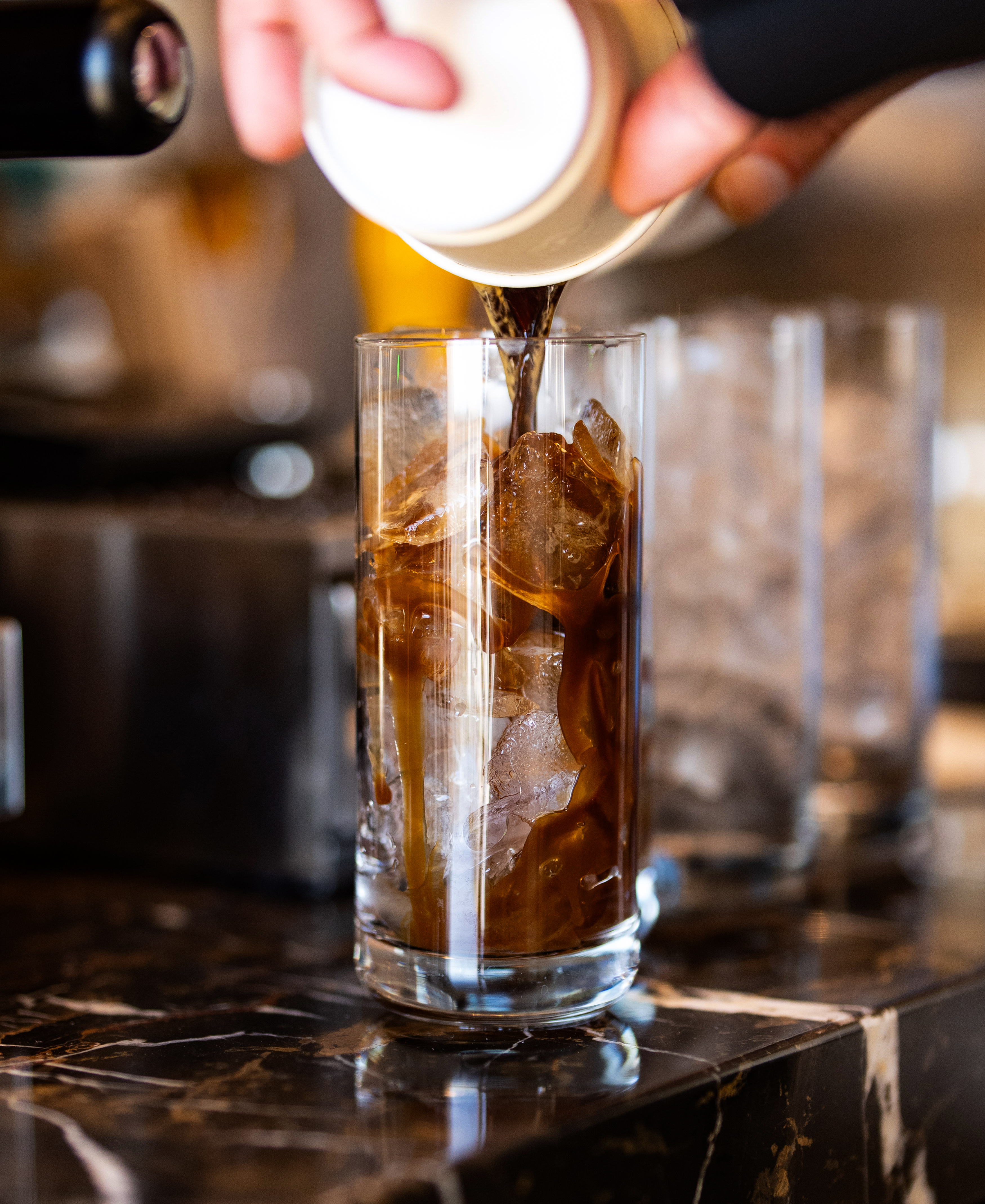 Milk pouring into iced espresso